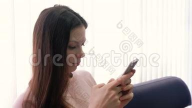 年轻的黑发女人<strong>正在</strong>手机上<strong>输入</strong>一条信息，看着屏幕。 侧视。